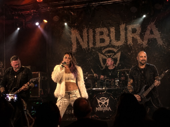 NIBURA live auf der Bühne vor dem Bandbanner